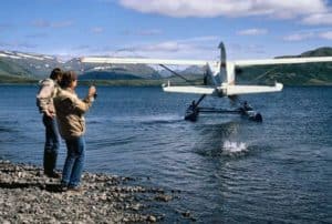 An angler battles a salmon as the float plane he just arrived in taxis away for take off. Such fly-in spots to remote areas of Alaska is among the best of the best for visiting anglers.