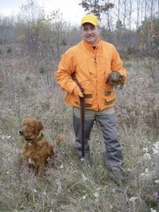 Jerry Dennis, of Traverse City, Michigan, displays a grouse that was flushed and retrieved by Gabe, the author’s golden retriever.