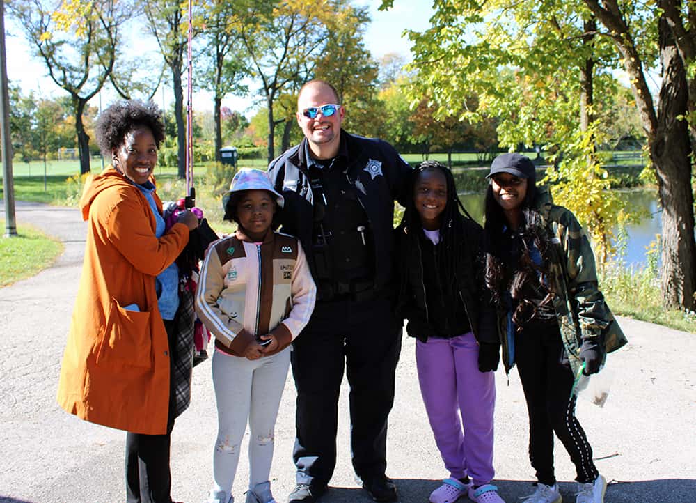 image: police officer with family at fishing event