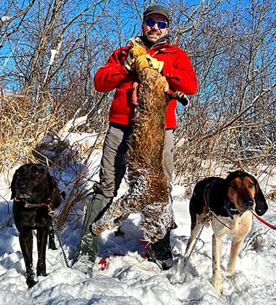 image: bobcat hunter with hounds