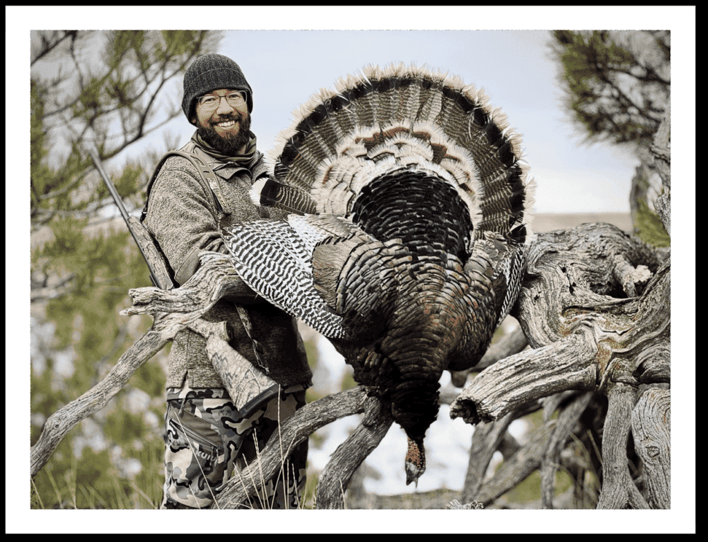 image: turkey hunter poses after a successful hunt in early spring