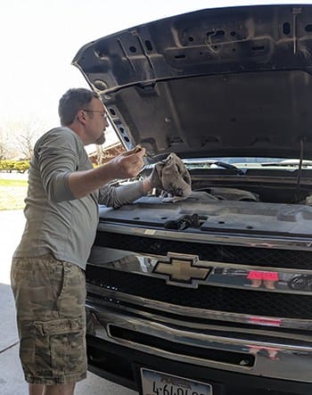 image: man checking car oil