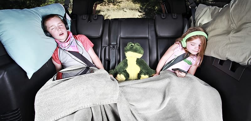 image: kids asleep in car with blankets