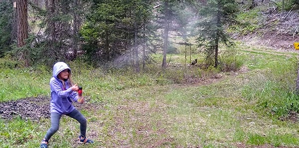image: kid using bear spray