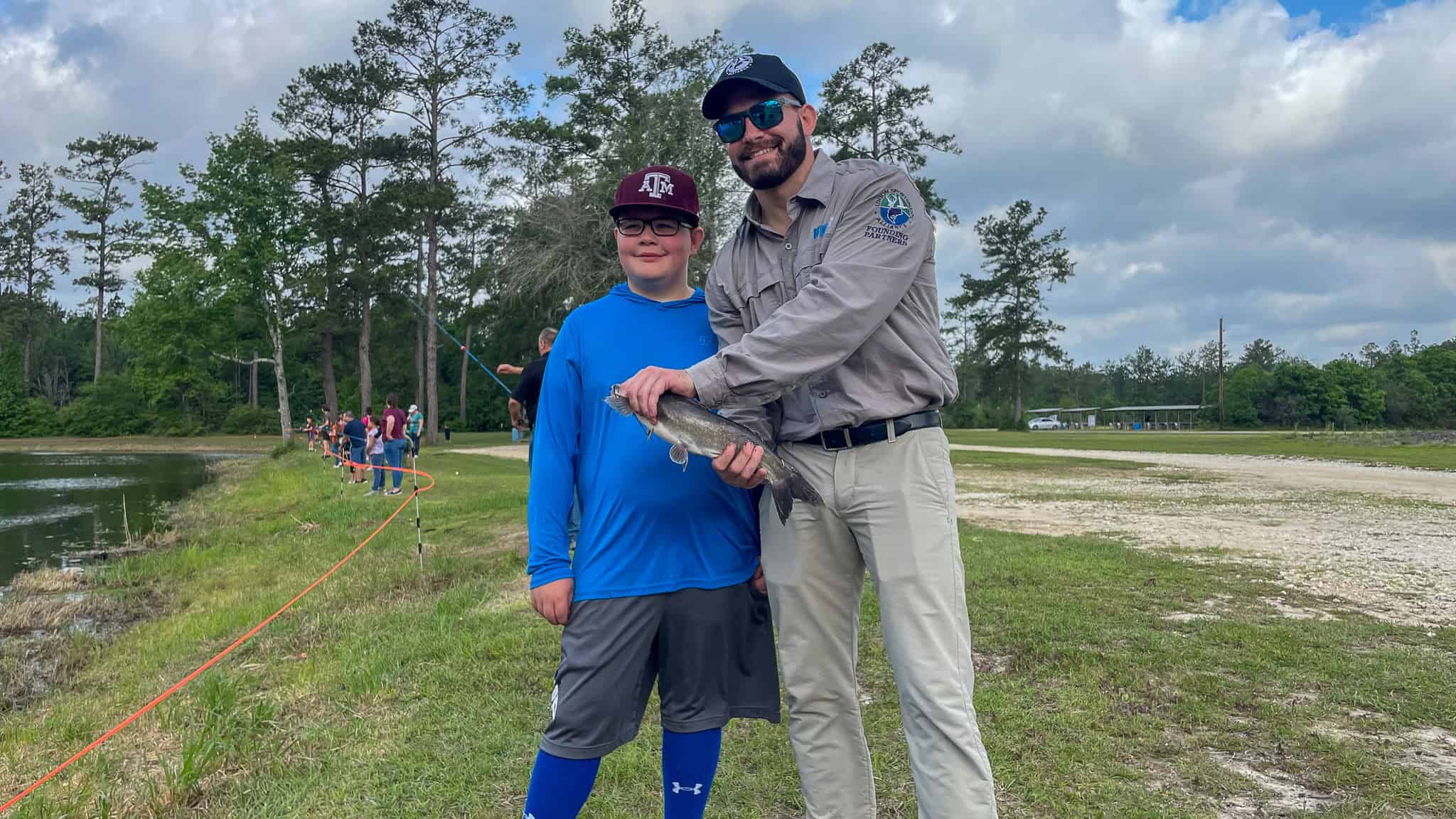 UIG Nick Giovenco poses with caught fish and young angler at fishing pond in Texas. 
