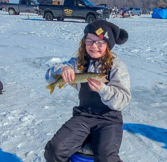 A youth angler smiles with a fish.