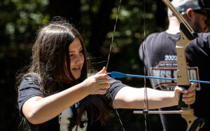 image: young girl trying archery
