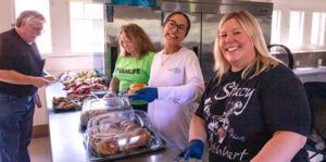 image: volunteers preparing to serve food.