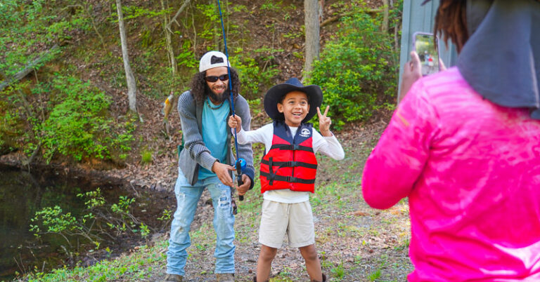 Youth angler taking photo with fish