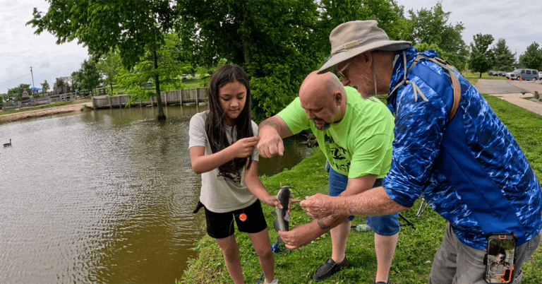 Union volunteers help a youth angler reel in a fish at the Lexington Take Kids Fishing Day.