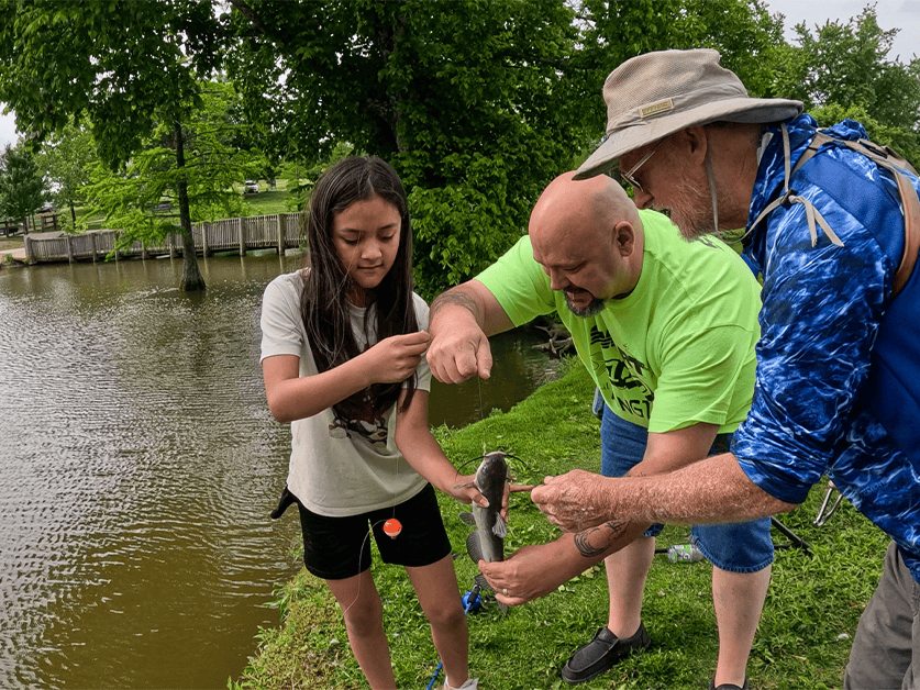 Union volunteers help a youth angler reel in a fish at the Lexington Take Kids Fishing Day.
