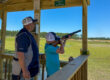 Youth shooter with volunteer at sporting clays range.