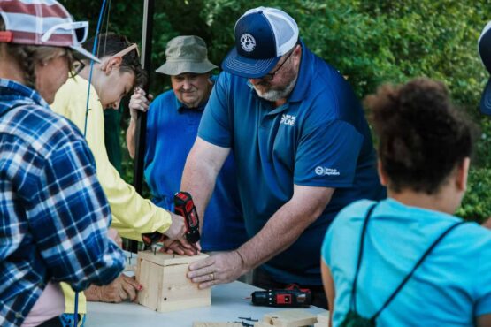 Volunteers help participants build birdhouses during the 4th Annual Flint Area Get Youth Outdoors Day.